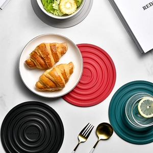 Red, black, and green round silicone heat resistant table mats with concentric ring texture