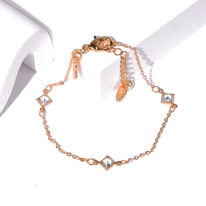 Detail of rose gold bracelet featuring zircon-encrusted charms and delicate linked chain