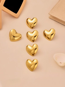 Detailed view of six 3D heart-shaped gold stud earrings in a high-polished finish