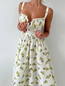 Detail of lemon print summer dress with ruffled neckline and delicate tie straps
