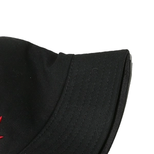 Λεπτομέρεια από ραφές σε μαύρο καπέλο bucket από καμβά με κόκκινο κέντημα