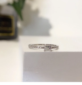 Macro detail of square cut zircon ring with silver plated band on artistic pedestal