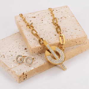 Parure de bijoux dorée avec collier trombone, boucles d'oreilles et cristaux scintillants