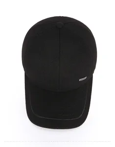 Close-up of black wool blend baseball cap with twill texture and silver metal side trim