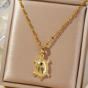 Elegant gold turtle pendant necklace with zircon accents in a luxury jewelry box