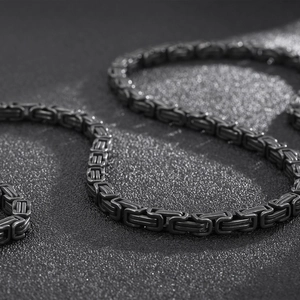 Macro shot of black titanium steel square weave chain with high-gloss metallic finish