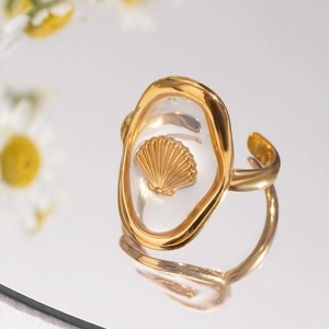 Macro shot of gold stainless steel ring with shell inlay on a mirrored surface