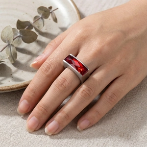Detailed view of matte silver ring with rectangular ruby stone worn on hand