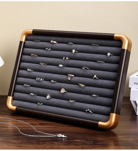 Detail of walnut wood jewelry tray with 10 velvet slots and gold metal corners
