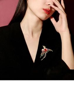 Exquisite phoenix brooch with colorful enamel and red gems pinned on a black suit blazer
