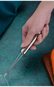 Close-up of stainless steel wire mesh strainer with durable handle held by hand