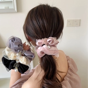 Detail of satin and mesh scrunchies with pearls and crystals shown on hair and hand