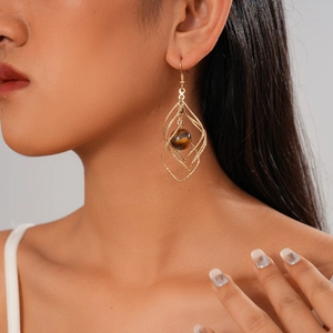Vintage geometric twisted diamond-shaped earrings with tiger eye stone on model