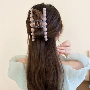Detail view of a large lavender resin claw clip holding hair in a stylish bun