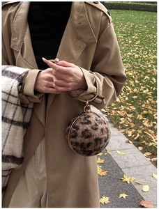 Detail of leopard print faux fur spherical bag with a round golden metal handle