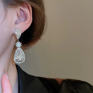 Close-up of silver water drop tassel earrings with sparkling rhinestones on model