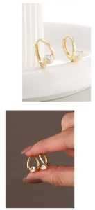 Macro detail of U-shaped gold earrings with sparkling round cubic zirconia stones