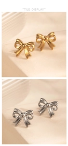 Macro detail of gold and silver bow stud earrings showing ribbon texture on stone