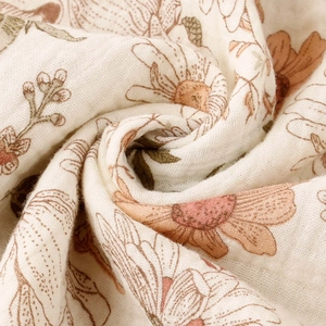 Macro shot of double-layer cotton muslin fabric featuring vintage sunflower prints and texture