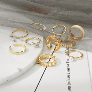 Set of 9 vintage gold-plated rings with pearls and butterfly design on marble display