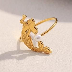Close-up of gold plated mermaid tail ring featuring a white round pearl inlay detail
