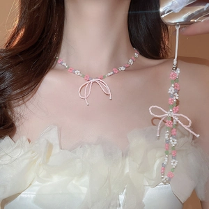 Close-up of handmade beaded floral necklace and phone strap with pink bows