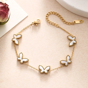 Detailed close-up of golden butterfly charms with mother-of-pearl texture and bead edges