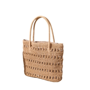 Handcrafted hollow straw woven beach tote bag in beige with top handles on white background