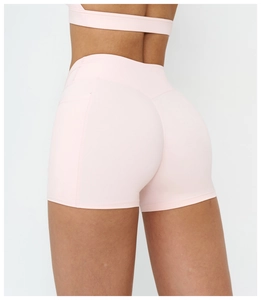 Detail of high-waist light pink yoga shorts featuring hidden side pockets and elastic fabric