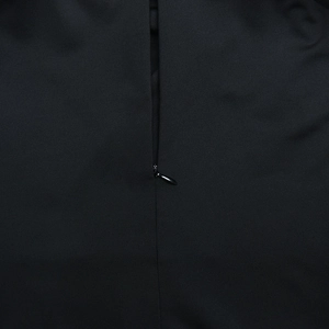 Detail shot of the hidden zipper on the black fabric of a halter neck dress