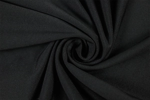 Detailed close-up of black fabric texture with elegant spiral pleated design and soft drape
