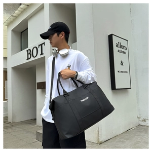 Outdoor shot of a black large capacity oxford travel bag with white lettering logo
