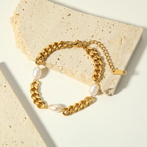 Macro detail of 18K gold-plated Cuban chain bracelet with natural freshwater pearls