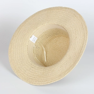 Détail de l'intérieur du chapeau en paille de papier beige avec bandeau et étiquette de soin
