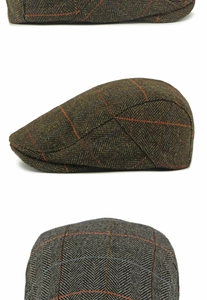 Detail of herringbone wool flat cap with olive green and orange windowpane check texture