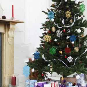 Fiocchi di neve glitterati in oro, argento, blu, verde e rosso decorati su un albero