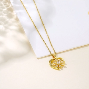 Collana a cuore dorata con pendente a girasole in zircone su sfondo crema minimale