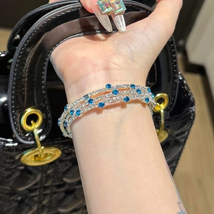 Three-layer silver bangle featuring sparkling zircon and light blue gemstones on wrist