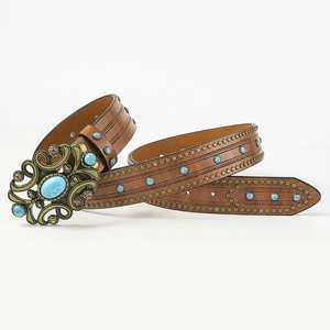 Detailed macro view of vintage buckle with turquoise stone and rivets on brown leather belt