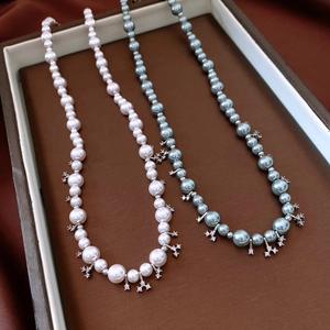 Detailed view of pearl necklaces with rhinestone star pendants in a premium jewelry box