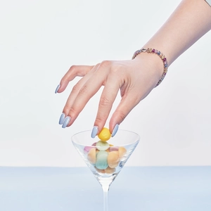 Rainbow gemstone S925 sterling silver bracelet worn by model with colorful candy props
