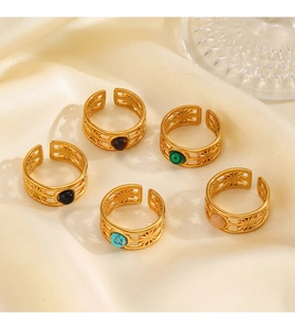 Set of five gold adjustable rings with vibrant inset stones on premium beige silk fabric