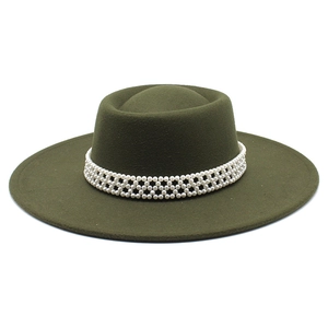 Close-up of olive green wool felt hat featuring elegant pearl beaded decorative band