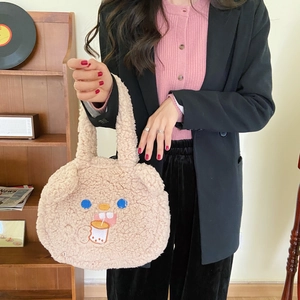 Detail of cute lamb wool tote bag with bear embroidery held by model in lifestyle scene