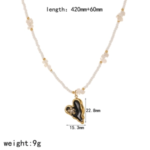 Golden heart necklace with black enamel inlay and sparkling floral centerpiece design