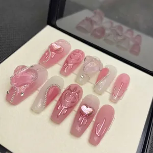 Pink and white handmade press-on nails with 3D heart charms and silver chain details