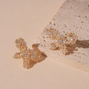 Close-up of gold-plated butterfly stud earrings featuring micro-pave white cubic zirconia