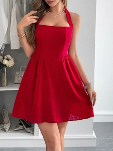 Detail of red halter neck backless A-line mini dress on a model in a modern dressing room