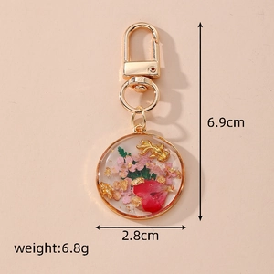 Detail view of goldfish keychain showing dimensions 6.9cm and 2.8cm on a beige background