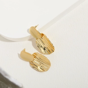 Modern 14K gold plated earrings with irregular wavy texture on geometric stone background